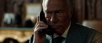 Movie still from “Inside Man” (2006), directed by Spike Lee – An older man talking on a phone while wearing a suit; Close Up shot, High angle