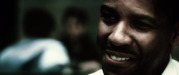 Movie still from “Inside Man” (2006), directed by Spike Lee – A man's face with a blurry background behind him; Extreme Close Up shot, Low angle