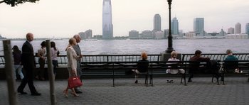 Movie still from “Inside Man” (2006), directed by Spike Lee – A group of people sitting on a bench near a body of water; Wide shot, High angle