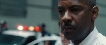 Movie still from “Inside Man” (2006), directed by Spike Lee – A man's face in front of a crowd; Close Up shot, Over the shoulder angle