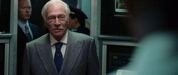 Movie still from “Inside Man” (2006), directed by Spike Lee – An older man wearing a suit and tie; Close Up shot, Over the shoulder angle