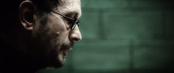 Movie still from “Inside Man” (2006), directed by Spike Lee – A person wearing glasses; Close Up shot, Over the shoulder angle