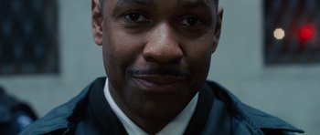 Movie still from “Inside Man” (2006), directed by Spike Lee – A person wearing a suit and tie; Close Up shot, High angle