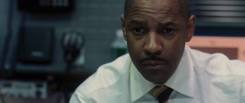 Movie still from “Inside Man” (2006), directed by Spike Lee – A person wearing a shirt and tie; Close Up shot, Low angle