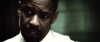 Movie still from “Inside Man” (2006), directed by Spike Lee – A man's face in a white shirt; Close Up shot, Over the shoulder angle
