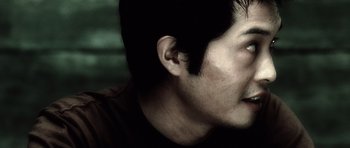 Movie still from “Inside Man” (2006), directed by Spike Lee – A man's face with dark background; Close Up shot, Low angle