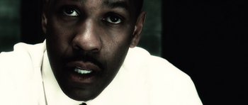 Movie still from “Inside Man” (2006), directed by Spike Lee – A person wearing a shirt and tie; Close Up shot, Low angle