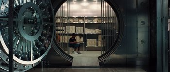 Movie still from “Inside Man” (2006), directed by Spike Lee – A man sitting in front of an open door in a room; Wide shot, High angle