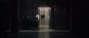 Movie still from “Inside Man” (2006), directed by Spike Lee – A jail cell with a light on the door; Extreme Wide shot, Low angle