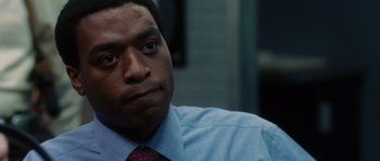 Movie still from “Inside Man” (2006), directed by Spike Lee – A person wearing a shirt and a tie; Close Up shot, Over the shoulder angle