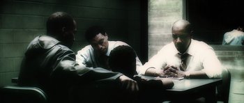 Movie still from “Inside Man” (2006), directed by Spike Lee – A group of men sitting around a table; Medium shot, Over the shoulder angle