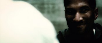 Movie still from “Inside Man” (2006), directed by Spike Lee – A man's face in the dark; Extreme Close Up shot, Over the shoulder angle