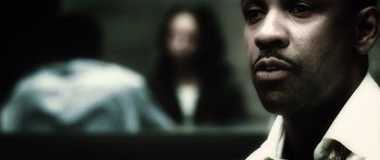 Movie still from “Inside Man” (2006), directed by Spike Lee – A man and a woman in the background; Close Up shot, Over the shoulder angle