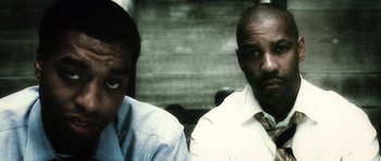 Movie still from “Inside Man” (2006), directed by Spike Lee – A couple of men standing next to each other; Close Up shot, Low angle