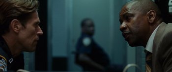 Movie still from “Inside Man” (2006), directed by Spike Lee – A police officer is reflected in a bathroom mirror; Close Up shot, Over the shoulder angle