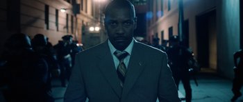 Movie still from “Inside Man” (2006), directed by Spike Lee – A man wearing a suit and tie standing in the street; Close Up shot, Low angle