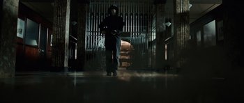 Movie still from “Inside Man” (2006), directed by Spike Lee – A person standing in front of a metal gate; Wide shot, Low angle
