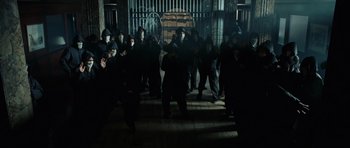 Movie still from “Inside Man” (2006), directed by Spike Lee – A group of people standing in front of a gate; Wide shot, High angle