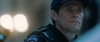 Movie still from “Inside Man” (2006), directed by Spike Lee – A person wearing a police uniform; Close Up shot, Over the shoulder angle