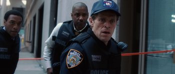 Movie still from “Inside Man” (2006), directed by Spike Lee – Two men in police uniforms are standing next to each other; Close Up shot, Over the shoulder angle