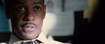 Movie still from “Inside Man” (2006), directed by Spike Lee – A man wearing a tie; Close Up shot, Low angle