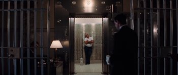 Movie still from “Inside Man” (2006), directed by Spike Lee – A man standing inside of a room with a bunch of cards; Wide shot, Low angle