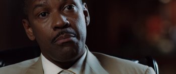 Movie still from “Inside Man” (2006), directed by Spike Lee – A person wearing a suit and tie; Close Up shot, Low angle