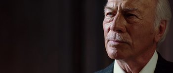 Movie still from “Inside Man” (2006), directed by Spike Lee – An older man wearing a suit and tie looking at the camera; Close Up shot, Low angle