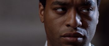 Movie still from “Inside Man” (2006), directed by Spike Lee – A man's eyes and face; Close Up shot, Low angle