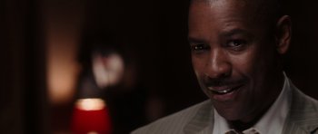 Movie still from “Inside Man” (2006), directed by Spike Lee – A person wearing a suit and tie; Close Up shot, Over the shoulder angle