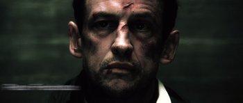 Movie still from “Inside Man” (2006), directed by Spike Lee – A person with a bruise on his face; Close Up shot, Low angle