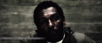 Movie still from “Inside Man” (2006), directed by Spike Lee – A person wearing a white shirt; Close Up shot, High angle