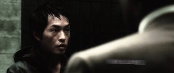 Movie still from “Inside Man” (2006), directed by Spike Lee – A man looking into a mirror in a dark room; Close Up shot, Low angle