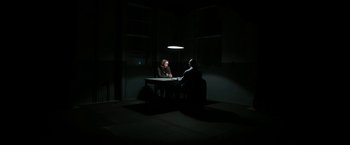 Movie still from “Insidious: Chapter 2” (2013), directed by James Wan – Two men sitting at a table in a dark room; Extreme Wide shot, High angle