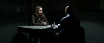 Movie still from “Insidious: Chapter 2” (2013), directed by James Wan – Two people sitting at a table talking to each other; Medium shot, Over the shoulder angle