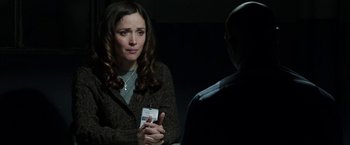 Movie still from “Insidious: Chapter 2” (2013), directed by James Wan – A woman sitting in front of a man holding a cell phone; Close Up shot, Over the shoulder angle