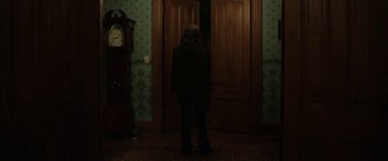 Movie still from “Insidious: Chapter 2” (2013), directed by James Wan – A woman standing in front of a door way; Wide shot, Over the shoulder angle