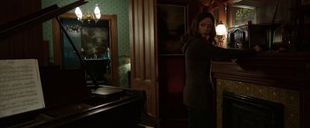 Movie still from “Insidious: Chapter 2” (2013), directed by James Wan – A woman standing next to a desk in a room; Wide shot, High angle