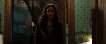 Movie still from “Insidious: Chapter 2” (2013), directed by James Wan – A woman standing in front of a door; Medium shot, Over the shoulder angle