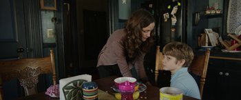 Movie still from “Insidious: Chapter 2” (2013), directed by James Wan – A woman standing at a table with a young boy; Medium shot, Over the shoulder angle