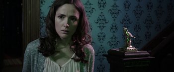 Movie still from “Insidious: Chapter 2” (2013), directed by James Wan – A woman in a white shirt is looking at the camera; Close Up shot, Over the shoulder angle