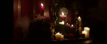 Movie still from “Insidious: Chapter 2” (2013), directed by James Wan – A skull sitting on top of a table next to candles; Medium shot, High angle