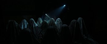 Movie still from “Insidious: Chapter 2” (2013), directed by James Wan – A group of people that are standing in the dark; Medium shot, Low angle