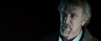 Movie still from “Insidious: Chapter 2” (2013), directed by James Wan – An older man with a beard and a mustache; Close Up shot, Over the shoulder angle