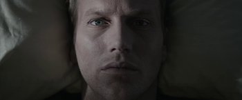 Movie still from “Insidious: Chapter 2” (2013), directed by James Wan – A person's face with a dark background; Extreme Close Up shot, Overhead angle