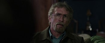 Movie still from “Insidious: Chapter 2” (2013), directed by James Wan – An older man wearing glasses and a brown jacket; Close Up shot, Over the shoulder angle