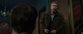 Movie still from “Insidious: Chapter 2” (2013), directed by James Wan – A man standing in front of a mirror in a room; Medium shot, Over the shoulder angle