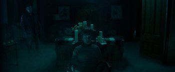 Movie still from “Insidious: Chapter 2” (2013), directed by James Wan – A woman sitting in a chair in a dark room; Wide shot, High angle