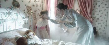Movie still from “Insidious: Chapter 2” (2013), directed by James Wan – A young child and an older woman in front of a mirror; Medium shot, Over the shoulder angle