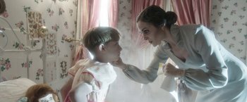 Movie still from “Insidious: Chapter 2” (2013), directed by James Wan – A young boy and a young woman touching each other's face; Medium shot, Over the shoulder angle